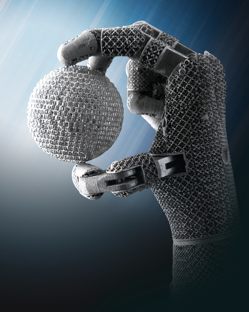 Historical robotic hand grasping a sphere, used as manipulation context.